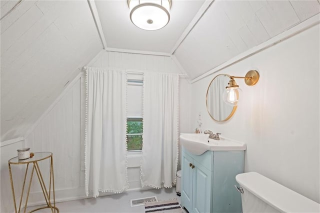 bathroom with vaulted ceiling, vanity, and toilet