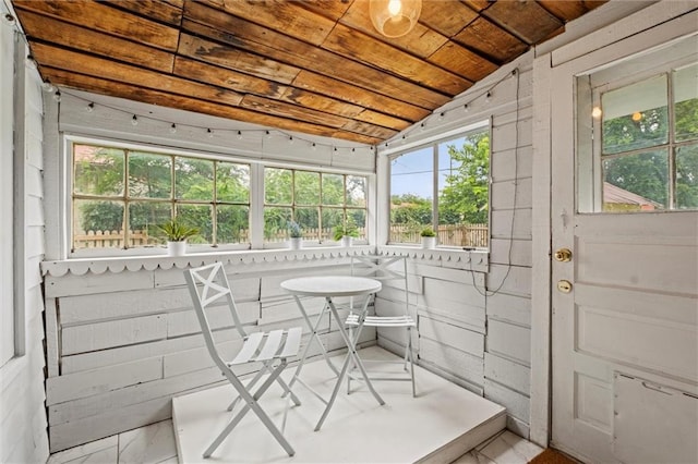 sunroom with wood ceiling, a healthy amount of sunlight, and vaulted ceiling