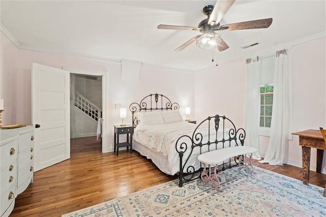 bedroom with crown molding, hardwood / wood-style floors, and ceiling fan