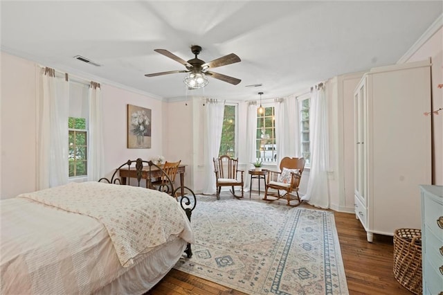 bedroom with crown molding, dark hardwood / wood-style floors, and ceiling fan