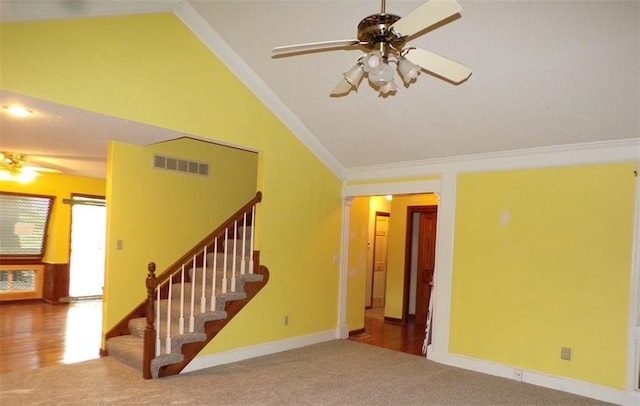 unfurnished living room with lofted ceiling, carpet floors, ornamental molding, and ceiling fan