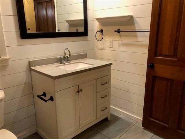 bathroom featuring vanity, tile patterned flooring, and toilet