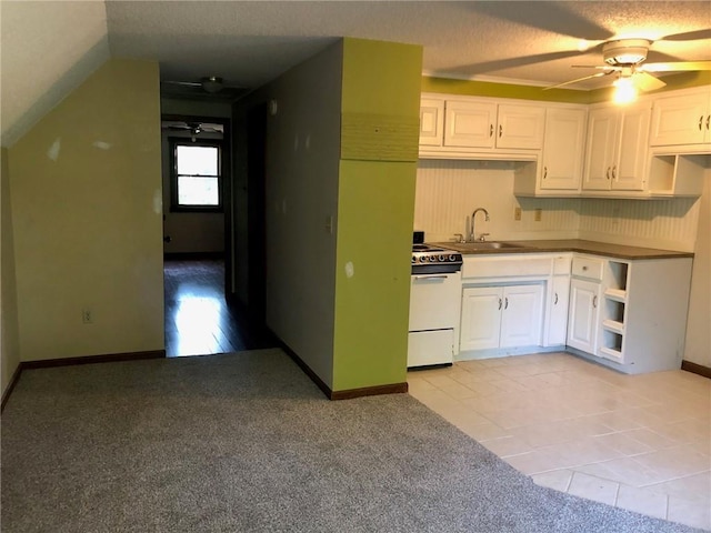 kitchen with sink, light tile patterned floors, ceiling fan, white cabinetry, and white electric stove