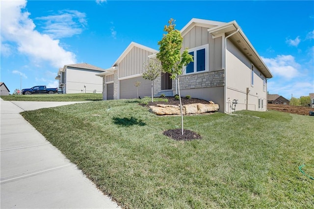 view of front facade featuring stone siding, driveway, a front lawn, and a garage