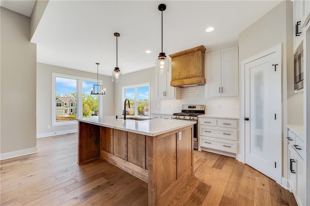 kitchen featuring light countertops, stainless steel appliances, light wood-type flooring, and a sink