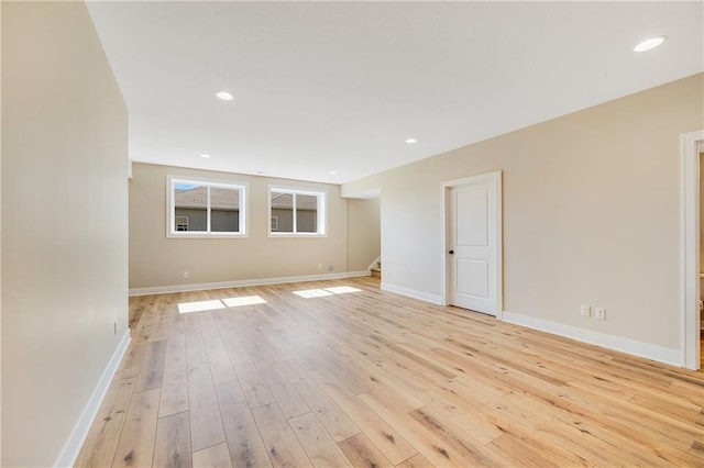 spare room featuring stairway, baseboards, recessed lighting, and light wood-style flooring