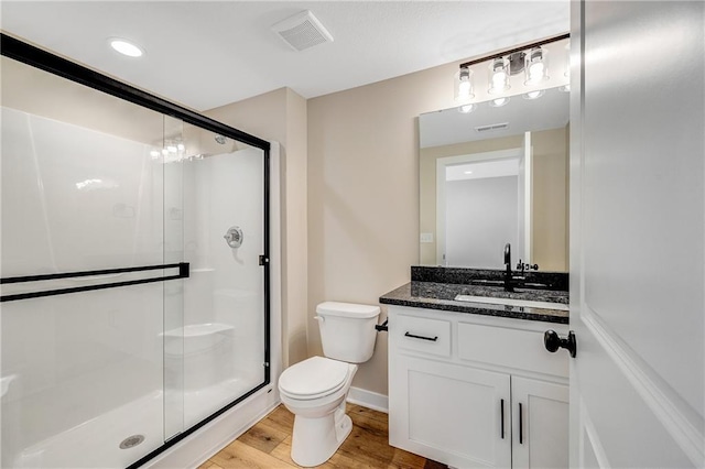 full bath with wood finished floors, visible vents, toilet, vanity, and a stall shower