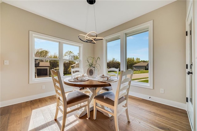 dining room featuring baseboards, a chandelier, and a healthy amount of sunlight