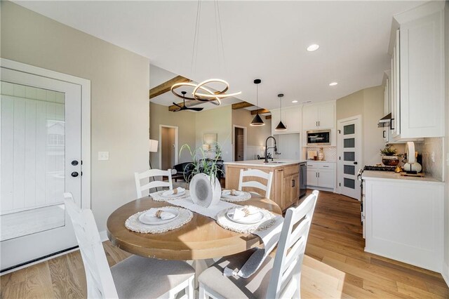 dining area featuring recessed lighting, light wood-style floors, baseboards, and a notable chandelier