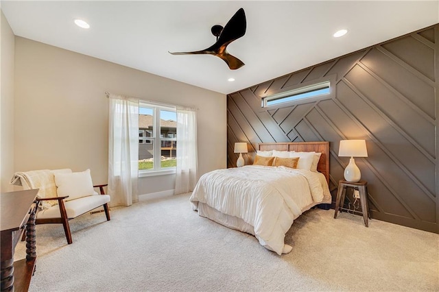 bedroom with light colored carpet, an accent wall, a ceiling fan, and recessed lighting