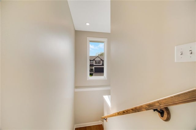 staircase featuring wood finished floors and baseboards