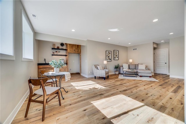 living area featuring baseboards, light wood-style floors, and recessed lighting