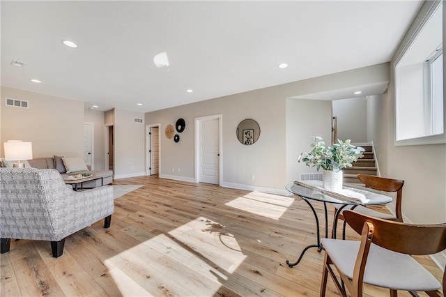 living area featuring recessed lighting, light wood-style flooring, visible vents, and stairway