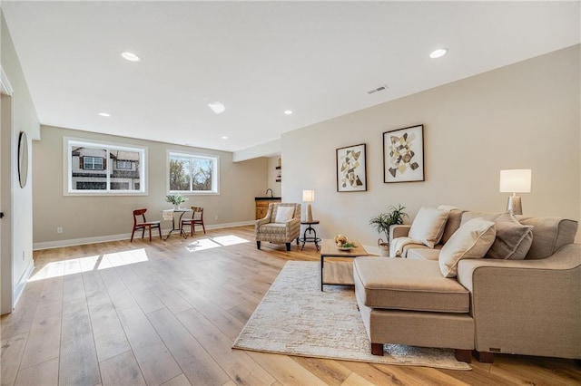 living room featuring recessed lighting, baseboards, visible vents, and light wood-style flooring