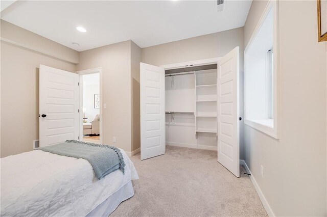 bedroom featuring recessed lighting, visible vents, a closet, baseboards, and light colored carpet