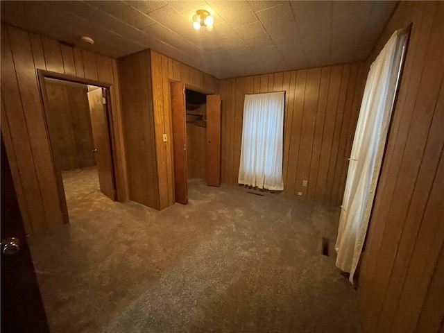 unfurnished bedroom featuring wooden walls and a closet