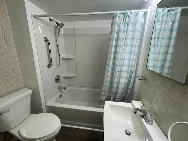 full bathroom featuring sink, shower / bath combination with curtain, and toilet