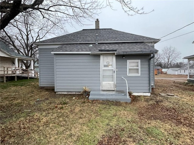 rear view of property with a yard