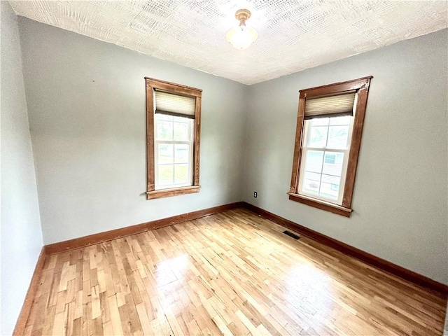 unfurnished room with wood-type flooring