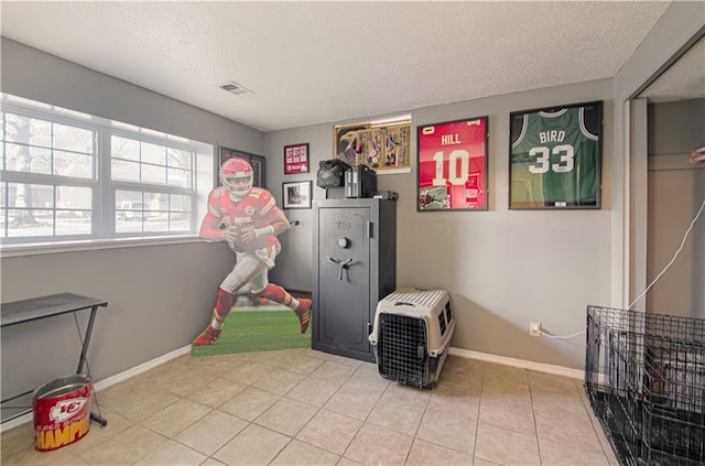 rec room featuring tile patterned floors and a textured ceiling