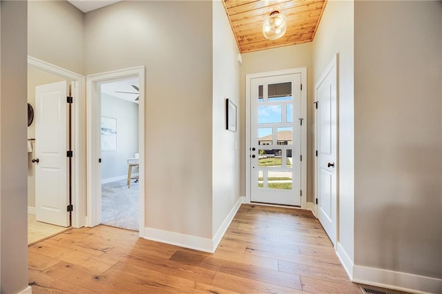 entryway with wood ceiling, baseboards, and light wood-style floors
