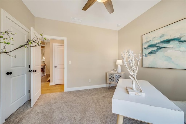 interior space with light carpet, baseboards, visible vents, and ceiling fan