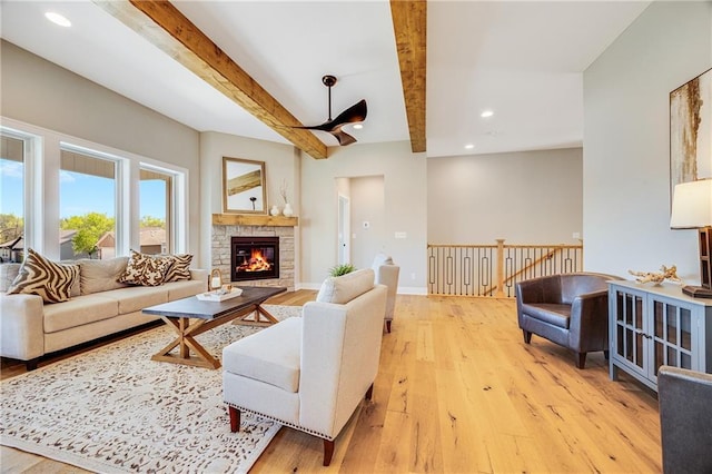living room with a fireplace, recessed lighting, beamed ceiling, and light wood-style flooring