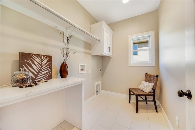 clothes washing area with hookup for a washing machine, hookup for an electric dryer, light tile patterned flooring, cabinet space, and baseboards