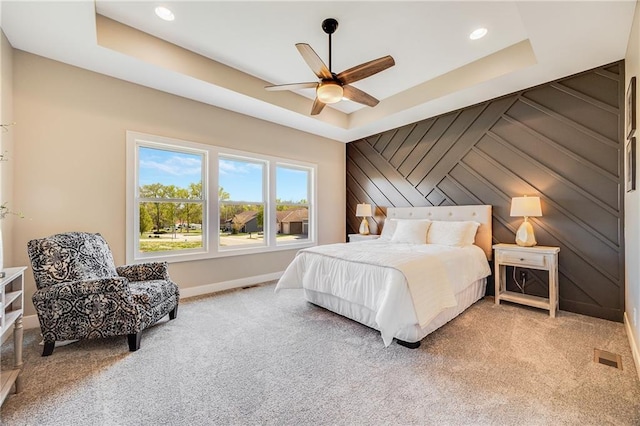 carpeted bedroom with a tray ceiling, baseboards, ceiling fan, and recessed lighting