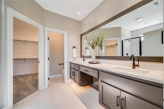 full bath with a spacious closet, visible vents, a sink, and toilet