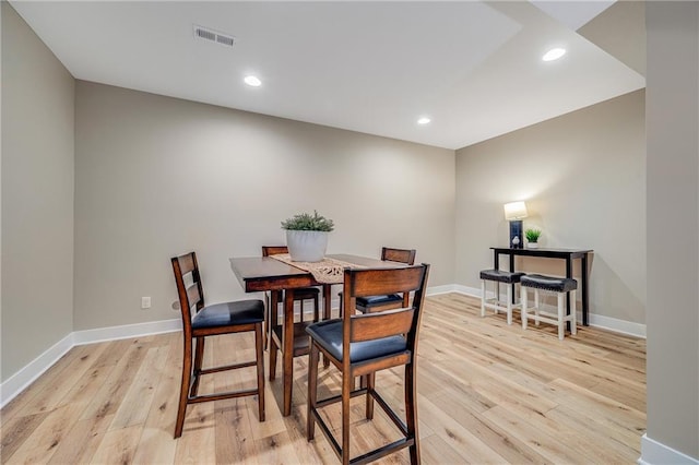 dining room with baseboards, light wood-style floors, and visible vents