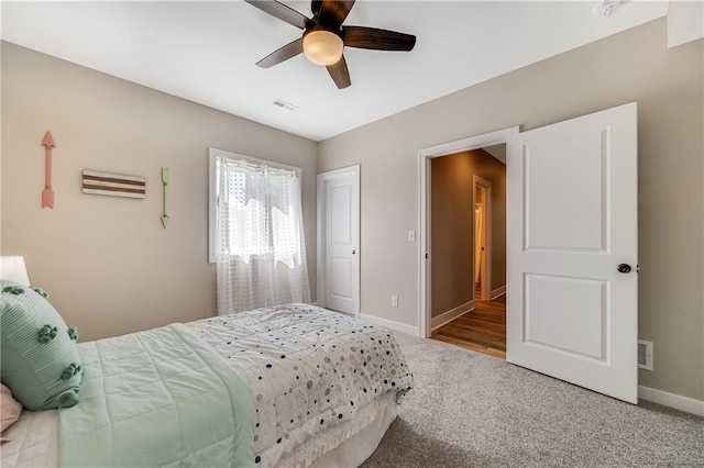 bedroom with baseboards, visible vents, carpet flooring, and ceiling fan