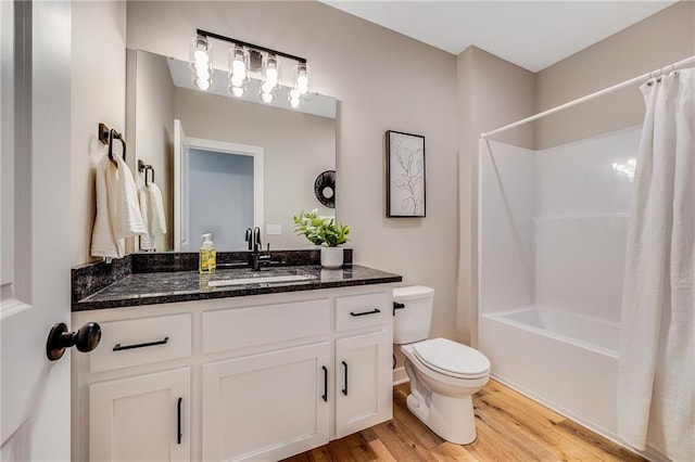 full bath featuring shower / bath combo, wood finished floors, vanity, and toilet