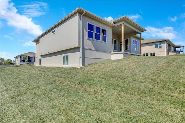 rear view of property featuring a lawn