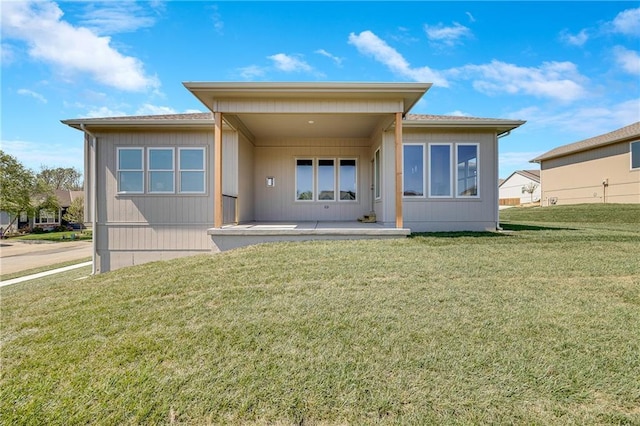 back of property featuring a lawn and a patio