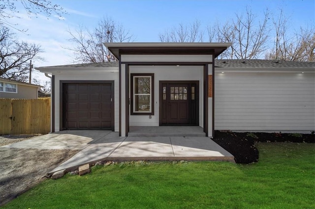 view of outdoor structure with concrete driveway, a garage, and fence