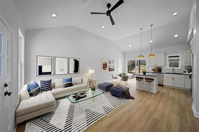 living room featuring recessed lighting, a ceiling fan, light wood-style floors, and vaulted ceiling