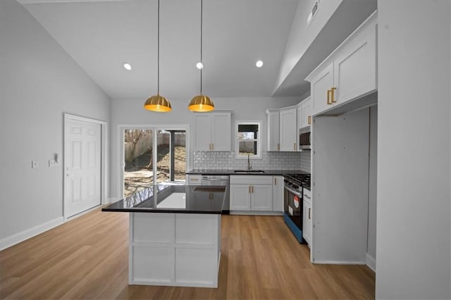 kitchen with a sink, tasteful backsplash, appliances with stainless steel finishes, and white cabinetry