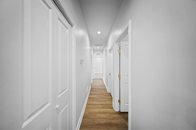 corridor featuring visible vents, recessed lighting, baseboards, and wood finished floors