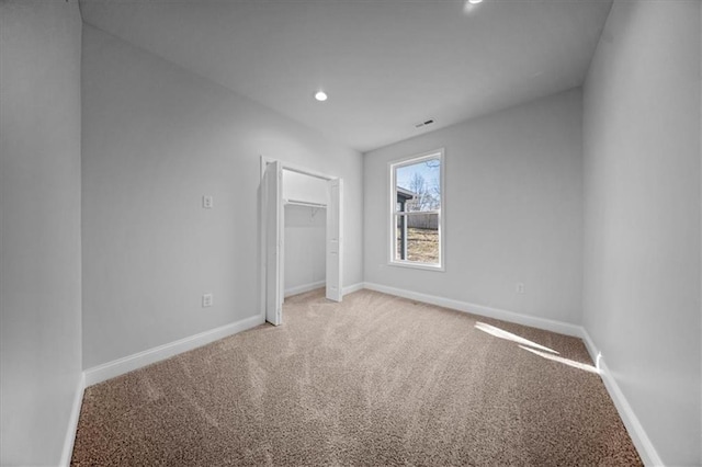 unfurnished bedroom featuring a closet, recessed lighting, carpet, and baseboards