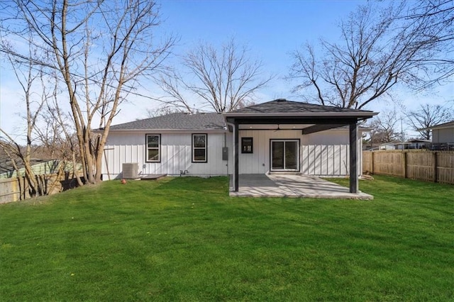 rear view of property with a patio, a fenced backyard, a lawn, and central AC