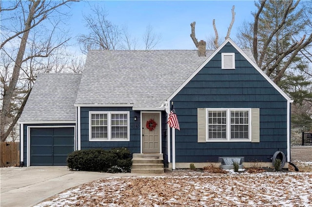 view of front facade with entry steps, an attached garage, driveway, roof with shingles, and a chimney