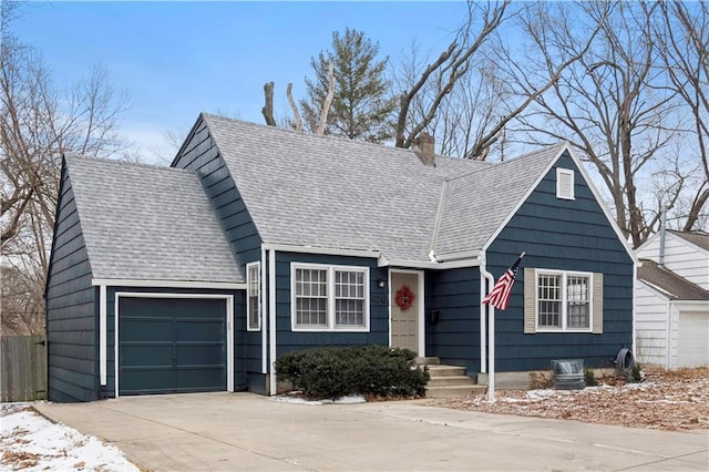 view of front of home featuring an attached garage, a shingled roof, a chimney, and concrete driveway