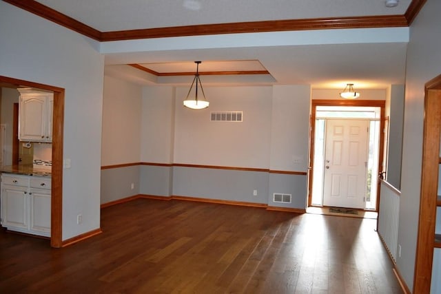 interior space featuring crown molding, dark wood-type flooring, and a tray ceiling