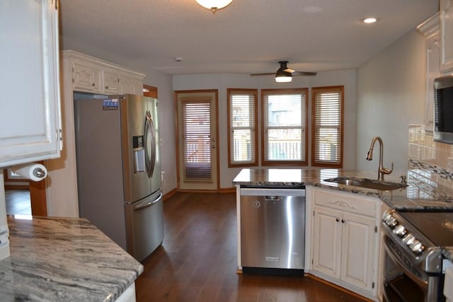 kitchen with sink, dark wood-type flooring, appliances with stainless steel finishes, white cabinetry, and tasteful backsplash