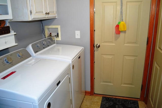 washroom featuring cabinets, light tile patterned floors, and washer and clothes dryer