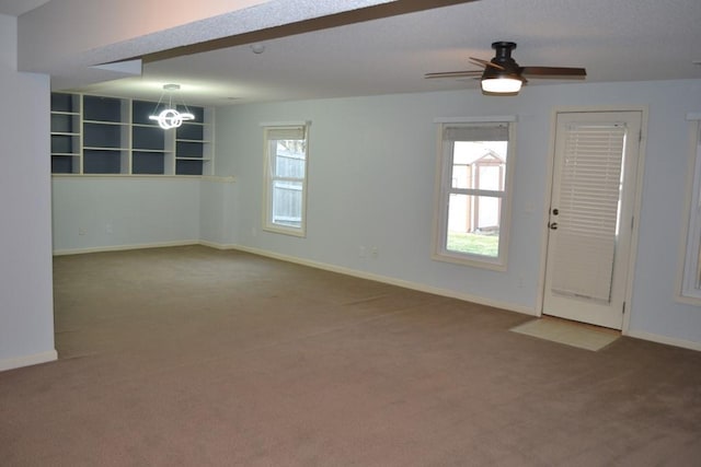 carpeted empty room with ceiling fan with notable chandelier