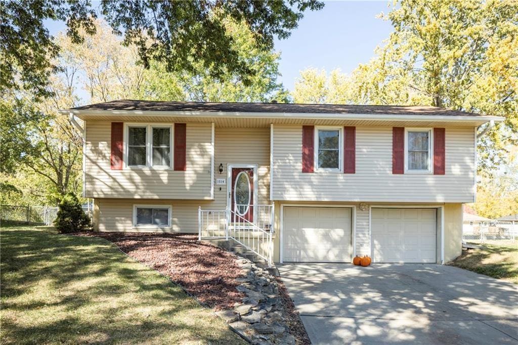 bi-level home with a garage and a front lawn