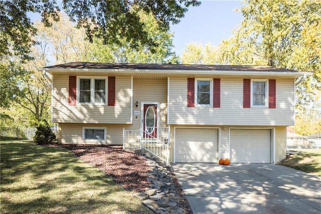 bi-level home with a garage and a front lawn