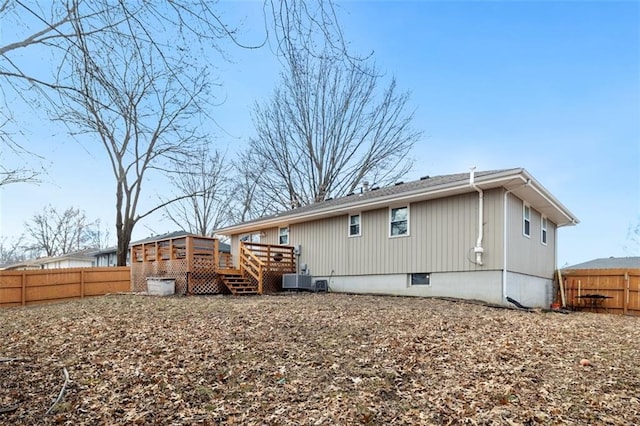 rear view of property featuring a wooden deck and central AC